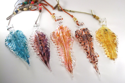 Solid sculpted hot formed feathers. Hangs from varying length leather and beaded cords. Suspend in window as a suncatcher. Approx. 4.5"-7" L