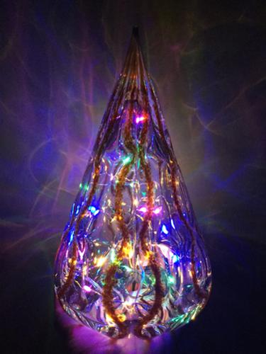Modern implied tree shaped lantern. Fill base with LED string lights for a festive display (lights not included but optional with purchase). Approx. 8-9"h x 4.5-5" w